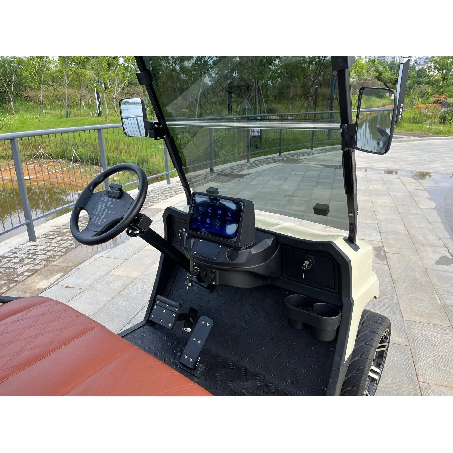 Interior view highlighting the steering wheel, dashboard with 10.25-inch screen, and foot pedals.