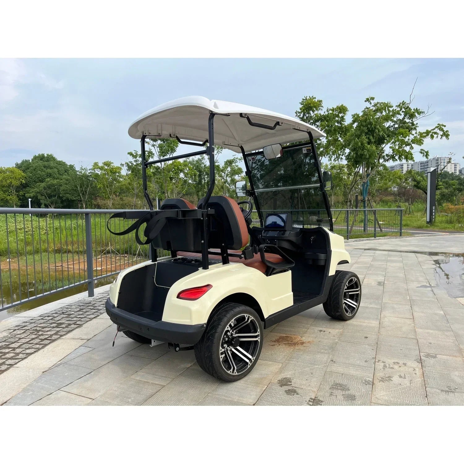 Rear view showing the open storage compartment, rear wheel, and back seats of the golf cart.