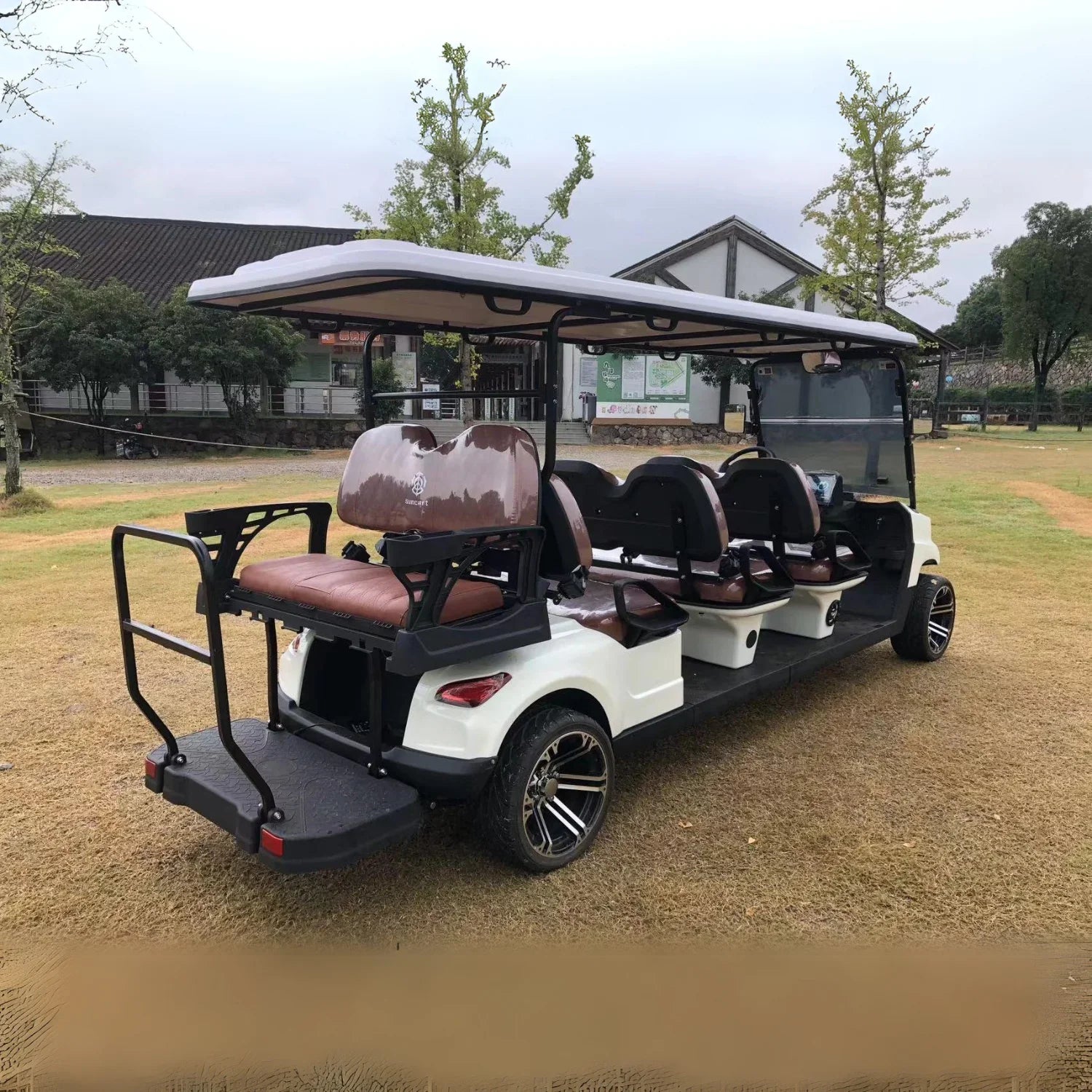 White golf cart with brown seats on a grassy area