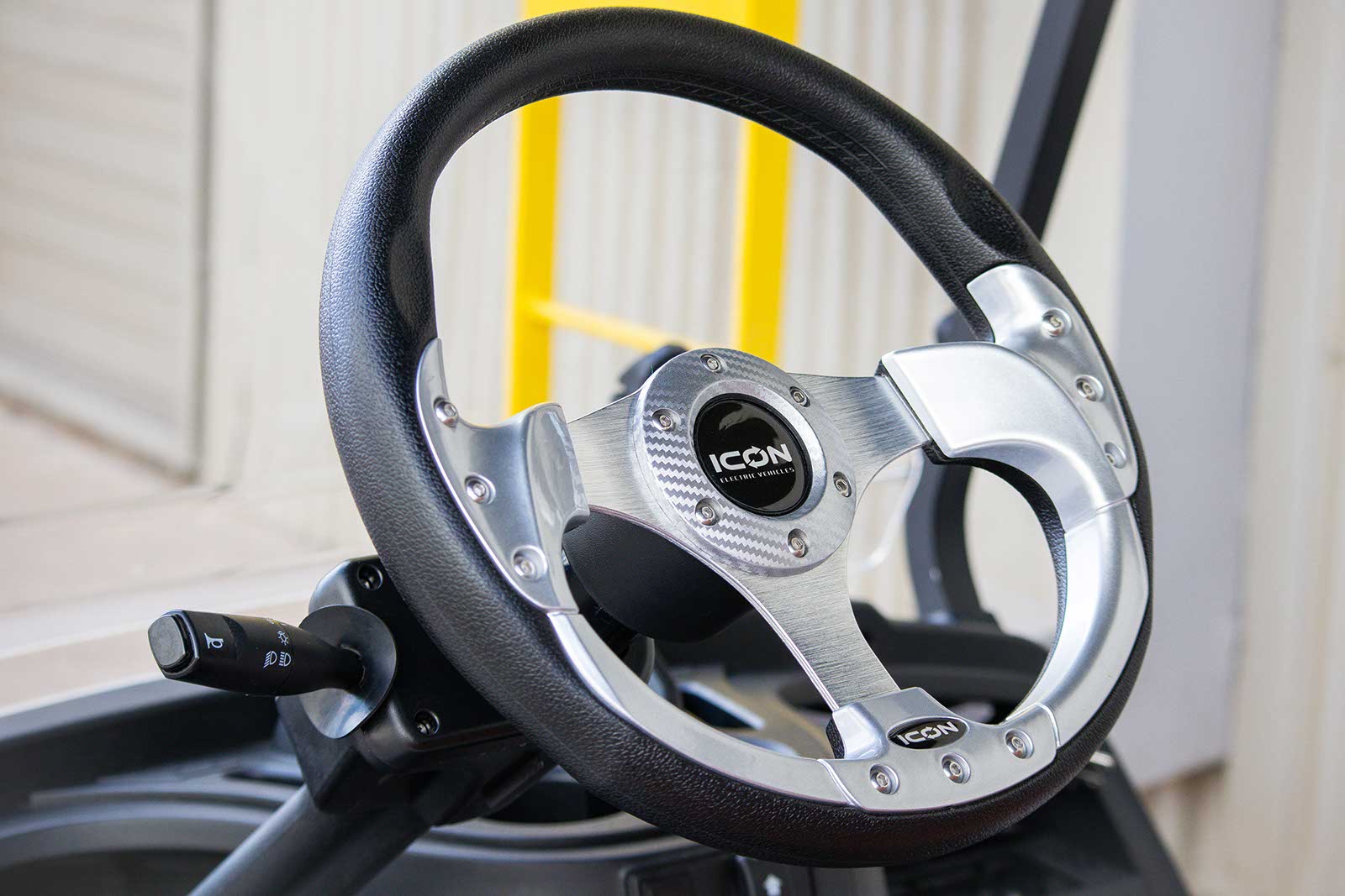 Steering wheel with 'Icon' branding on a blurred background