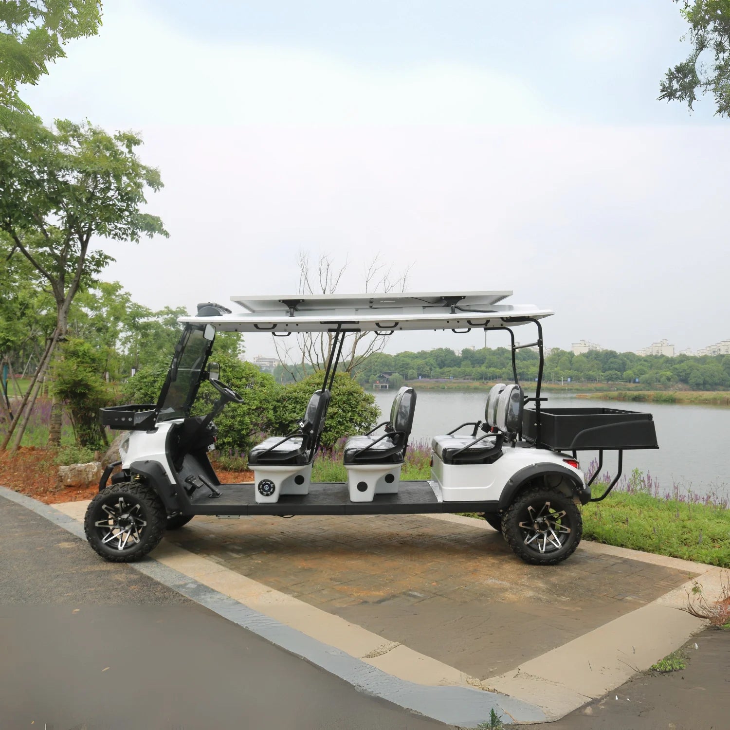 Electric golf cart on a paved path with trees and water in the background